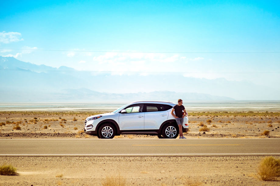 Man standing on side of road with car photo | Thompson Insurance | Auto Insurance